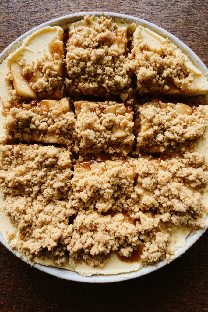 Layering caramel apple cheesecake bars in baking dish