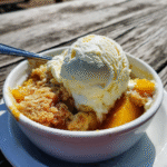 summer peach cobbler dessert with vanilla ice cream