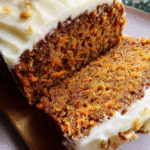 carrot spice loaf with cream cheese frosting on a cooling rack