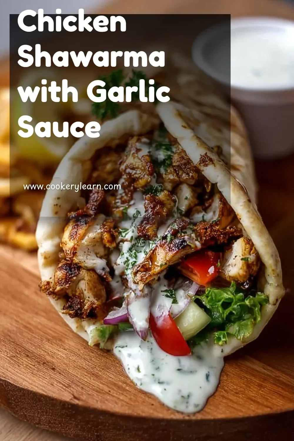 Plate of chicken shawarma with garlic sauce on a bed of fresh vegetables