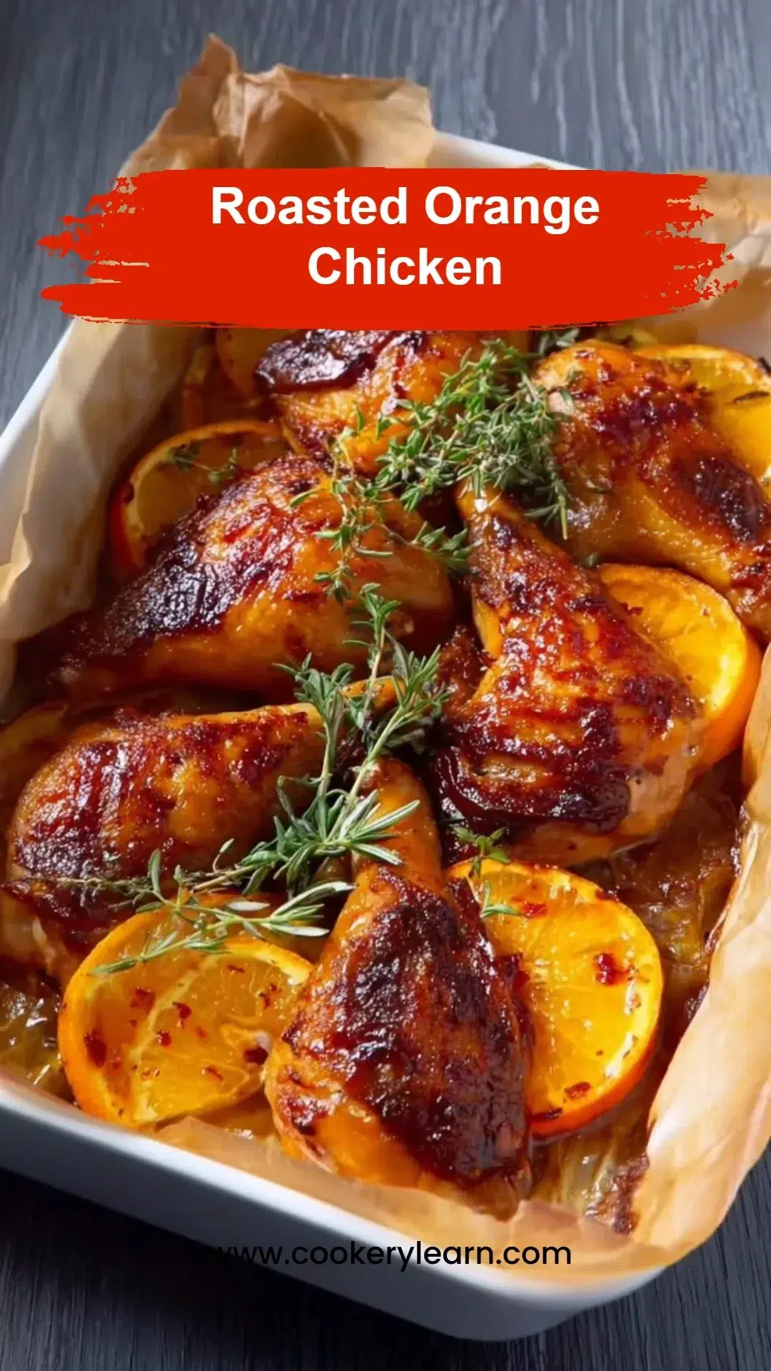 Plate of roasted orange chicken garnished with herbs and orange slices.