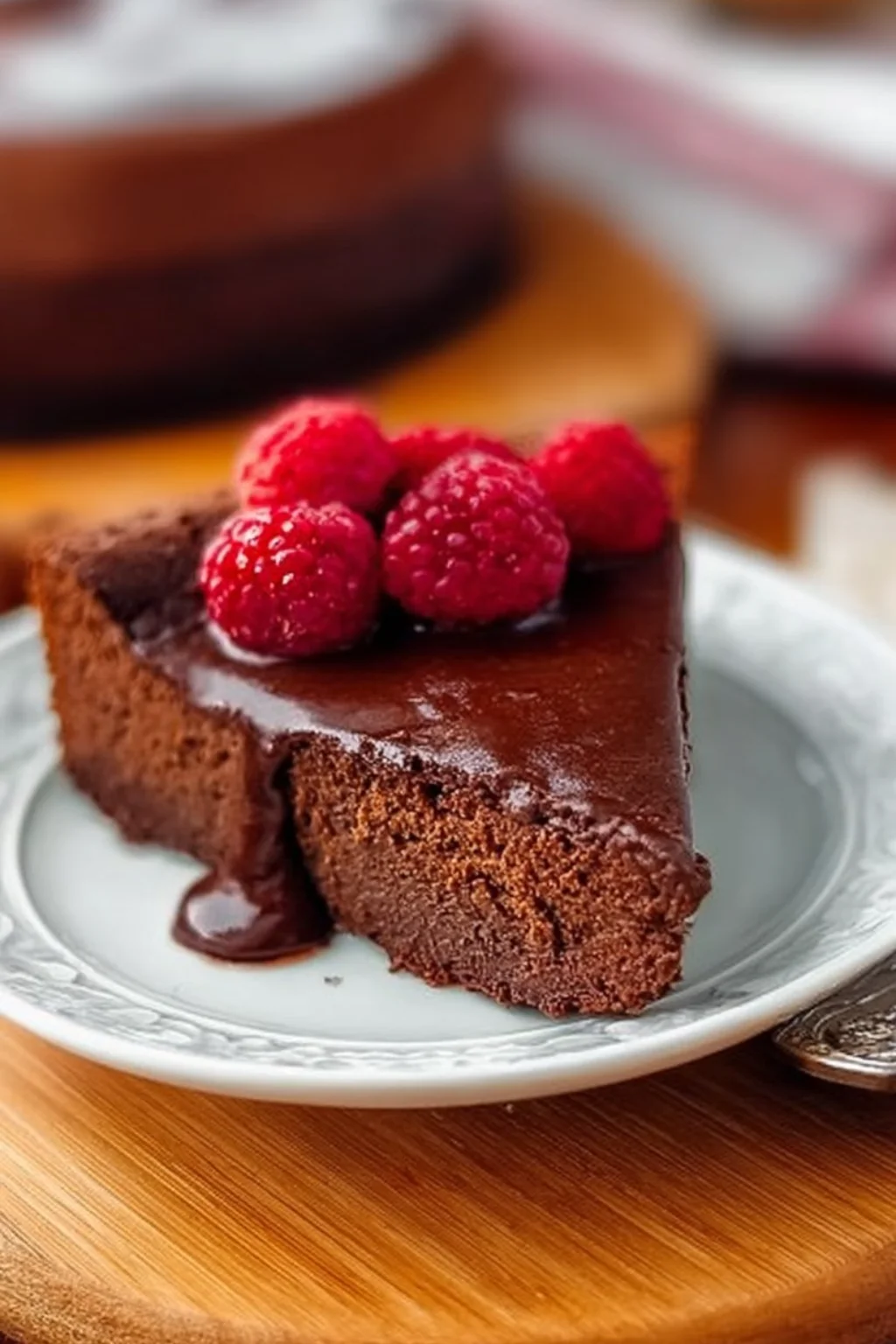Decadent flourless chocolate cake topped with ganache and fresh berries